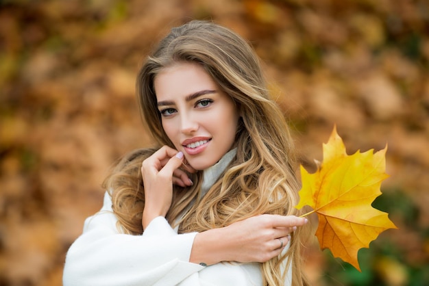 Closeup portrait of beautiful autumn woman outdoors Pretty tenderness model looking at camera