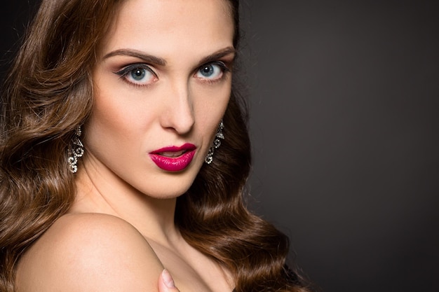 Photo closeup portrait of beautiful model lady with red lips looking at camera.