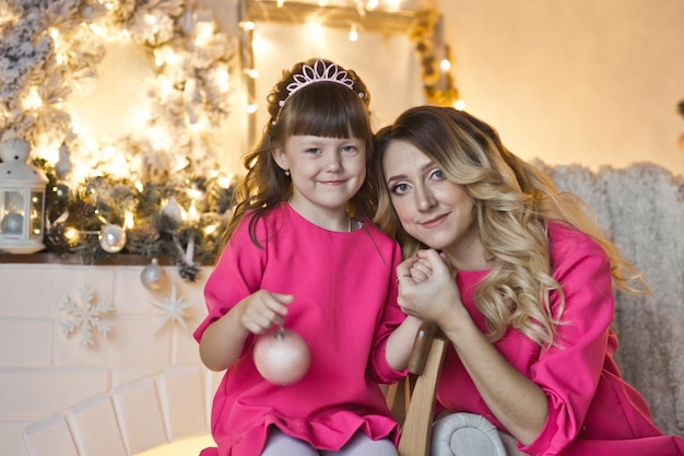 Closeup portrait of a beautiful mom with her daughter on the Christmas