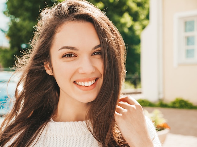 Photo closeup portrait of beautiful smiling brunette model. trendy girl posing in the street