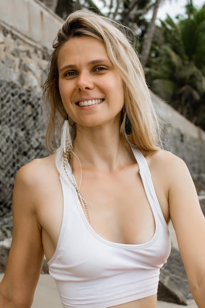 Closeup portrait of beautiful smiling female relaxing in the nature on warm sunny day Vertical photo