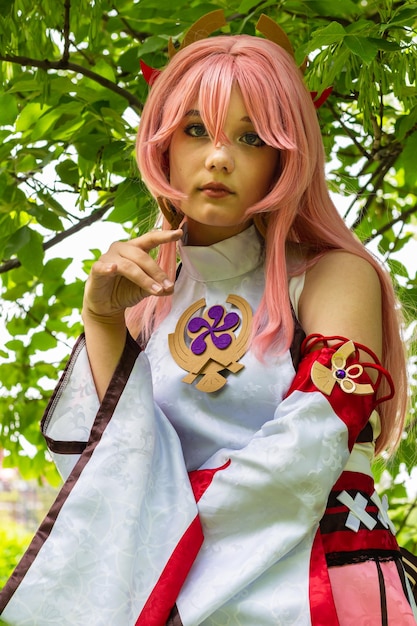 Closeup portrait of beautiful teenage girl in YAEMIKO anime costume in park outdoors editorial