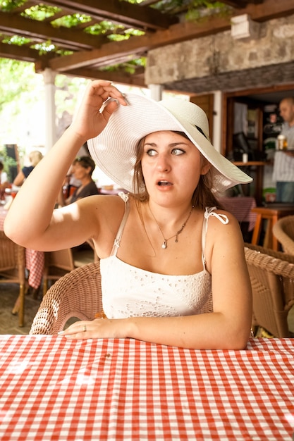 Closeup portrait of beautiful woman in restaurant looking with amazement