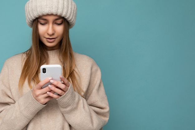 Closeup portrait beautiful young blonde woman wearing stylish beige warm sweater and