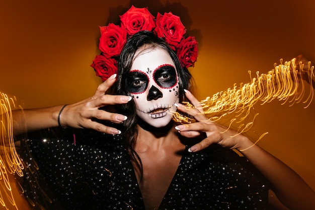 Closeup portrait of bold female model of Mexican appearance Brunette with beautiful manicure is looking confidently at camera