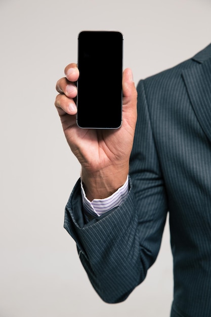 Closeup portrait of a businessman showing blank smartphone screen isolated