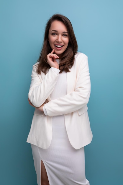 Closeup portrait of caucasian brunette with long hair woman in white dress and jacket posing on