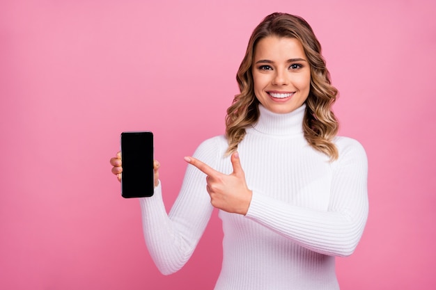 Портрет крупным планом веселой девушки, показывающей новый крутой телефон