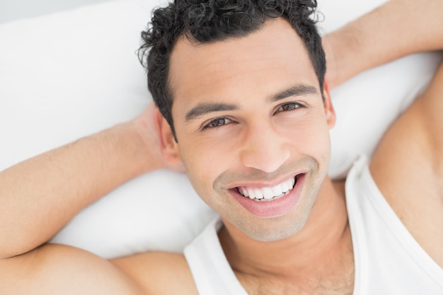 Closeup portrait of a cheerful man resting in bed