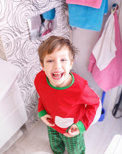 Closeup portrait of child kid toddler boyl in bathroom toilet going to washing face hands lifestyle home style everyday moments morning bedtime routine