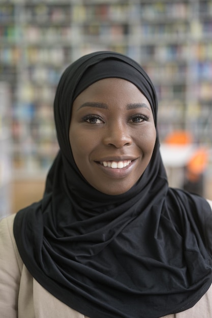 Closeup portrait of confident smiling muslim student wearing black hijab education concept