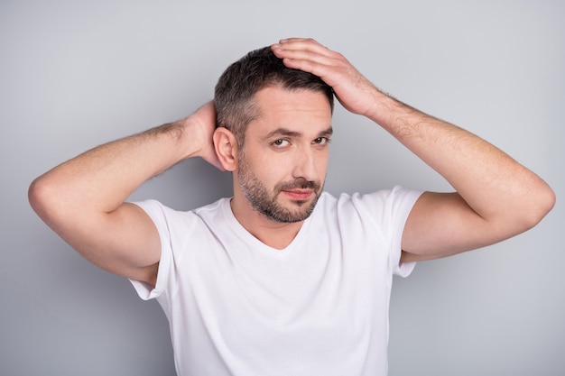 Closeup portrait of content brunet guy touching caressing hairstyle