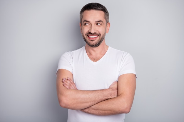 Closeup portrait of curious muscular guy folded arms look empty space