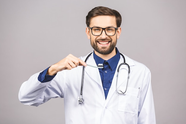 Ritratto del primo piano di un dentista che tiene uno spazzolino da denti, isolato