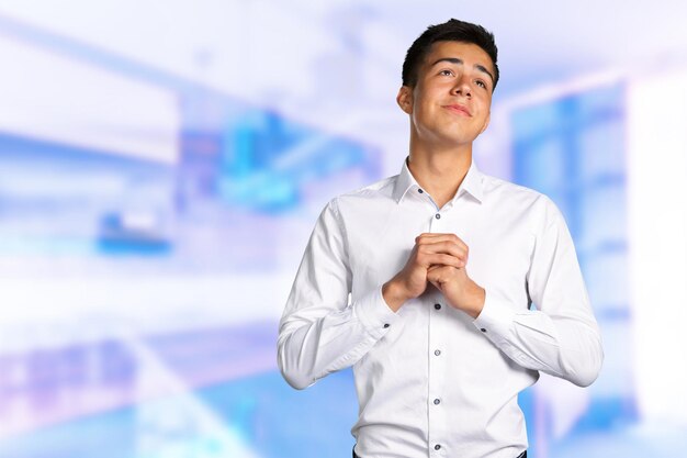 Closeup portrait of desperate young man showing clasped hands