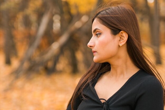 Closeup portrait of diversity young beautiful confident indian asian woman in black dress in fall