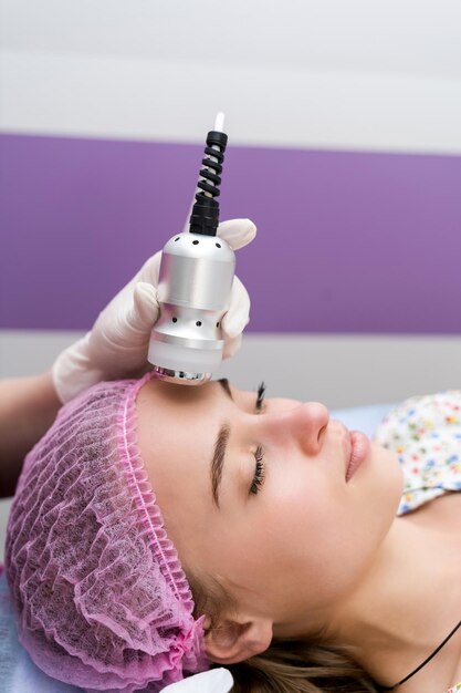 Closeup portrait of female face with closed eyes getting microdermabrasion procedure in a beauty parlour Woman laying on professional cometology table