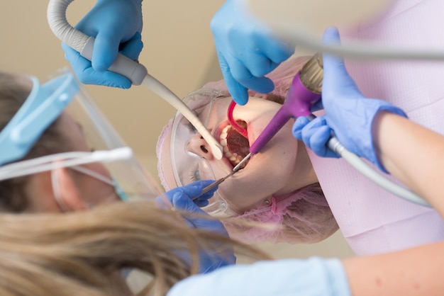 Ritratto del primo piano di una paziente femminile al dentista nella clinica giovane femmina bionda che apre la sua bocca w
