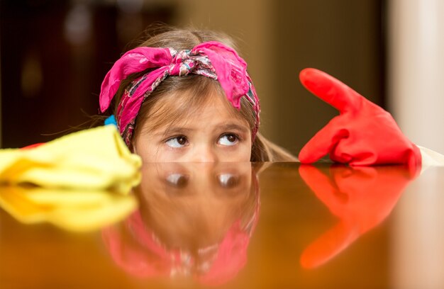 Closeup portrait of girl looking at finger in gloves covered with dust