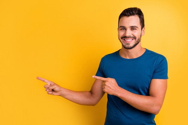 Closeup portrait of glad cheery guy pointing two forefingers