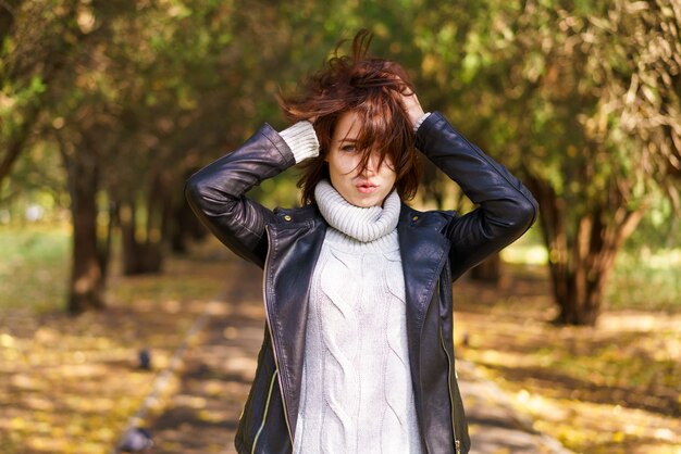 Closeup portrait of hand of attractive stylish woman shaggy hair walking in the park wearing black l...