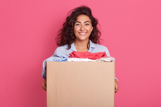 Closeup portrait of happy caucasian brunette woman holding carton box with donation