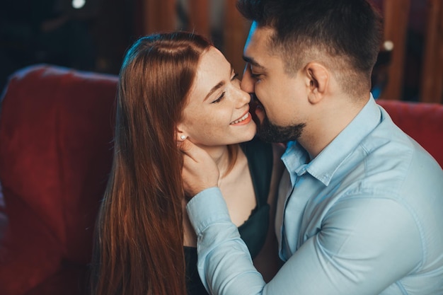 Closeup portrait of happy caucasian couple kissing and enjoying a good time together on valentine da...