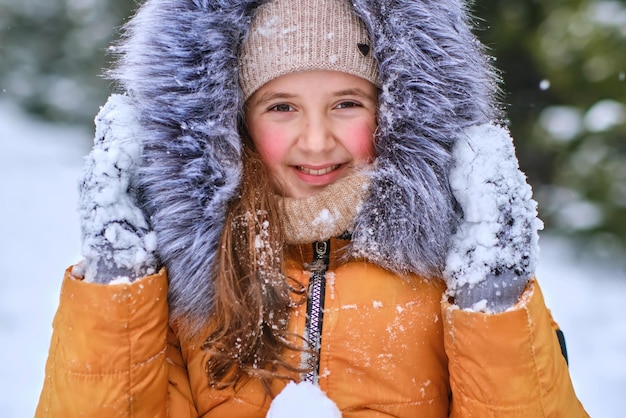 Closeup portrait of a happy girl in a furry hood