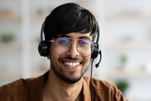 Photo closeup portrait of happy indian man using headset