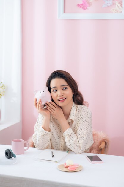 근접 촬영 초상화 행복, 웃는 비즈니스 우먼, 핑크 돼지 저금통을 들고