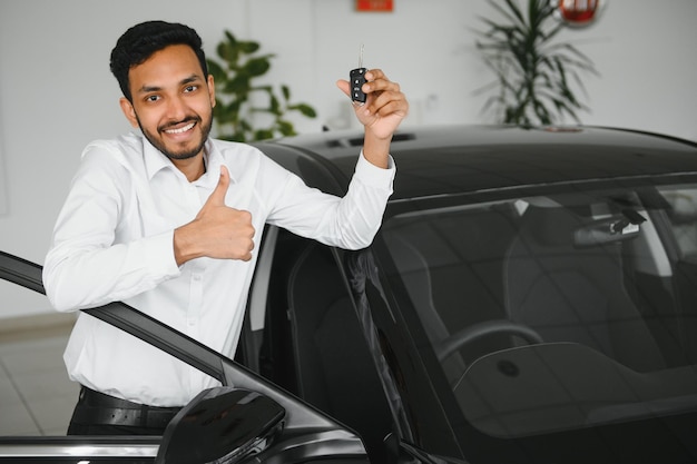 Closeup portrait happy smiling young man buyer showing keys of his new car