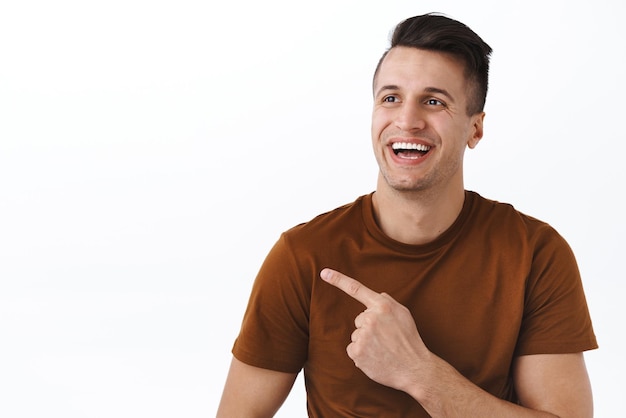 Closeup portrait of joyful goodlooking caucasian adult man seeing interesting chart or product picking item in store pointing finger upper left corner as making choice smiling pleased