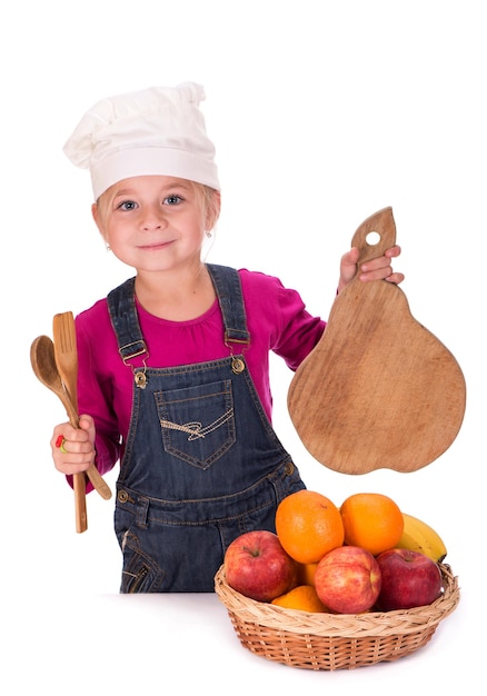 Ritratto del primo piano di una bambina che tiene frutta mele banane e arance ed elettrodomestici da cucina isolati su uno sfondo chiaro