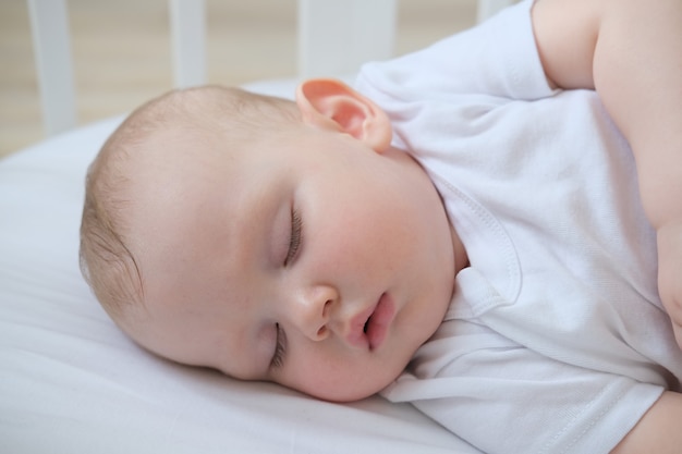 Closeup portrait of a little sleeping baby in a crib