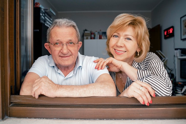 Closeup portrait of loving couple husband and wife family standing by window woman hugging her