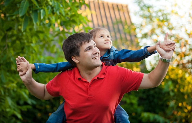 Closeup portrait of man playing with daughter seated on his shoulders