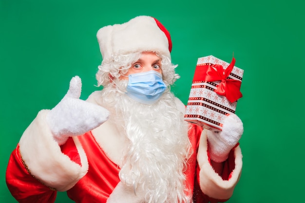 Closeup portrait of man with santa costume and face mask. New normal