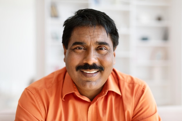 Closeup portrait of mature indian man posing at home