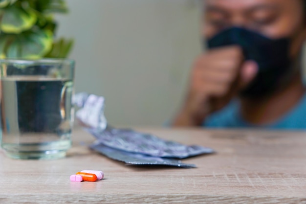 a closeup portrait of medicine with a man wearing a mask in the background