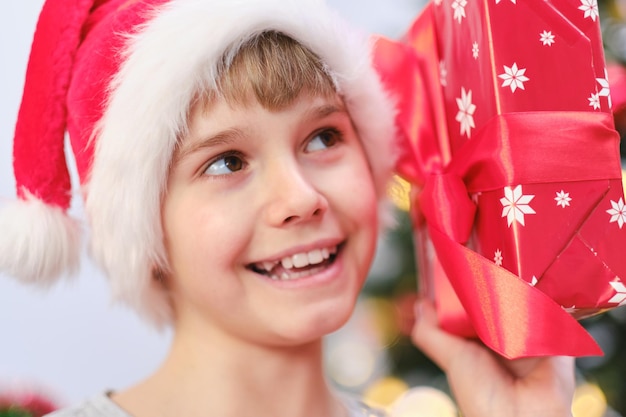 写真 彼の手に贈り物を持つクリスマスの子供のポートレート、クローズ アップ