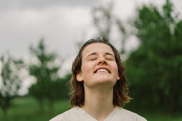 写真 10代の少女のクローズアップの肖像画屋外で暖かい夏の雨