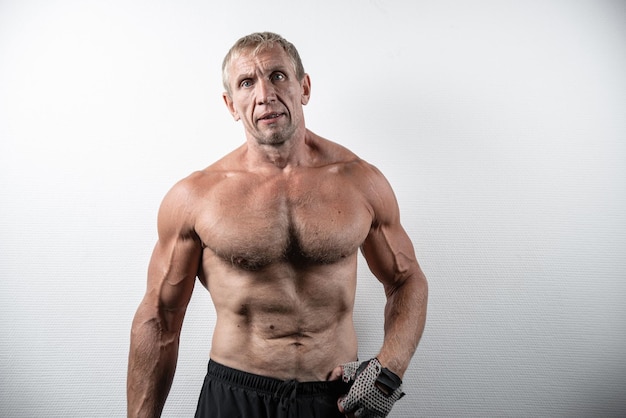 Closeup portrait of old brutal bodybuilder with serious face posing isolated on white background Muscular adult male with naked torso