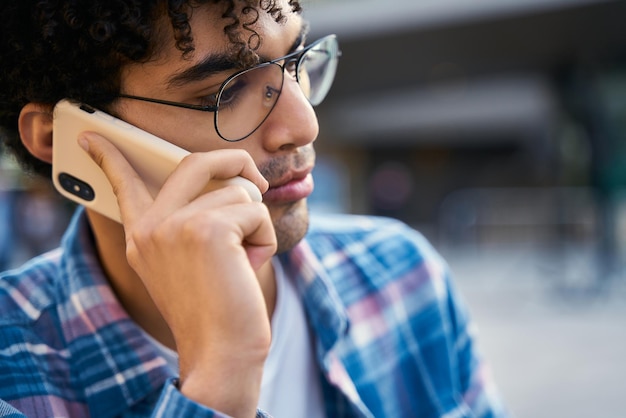 Closeup portrait of pensive middle eastern man talking on mobile phone on the street