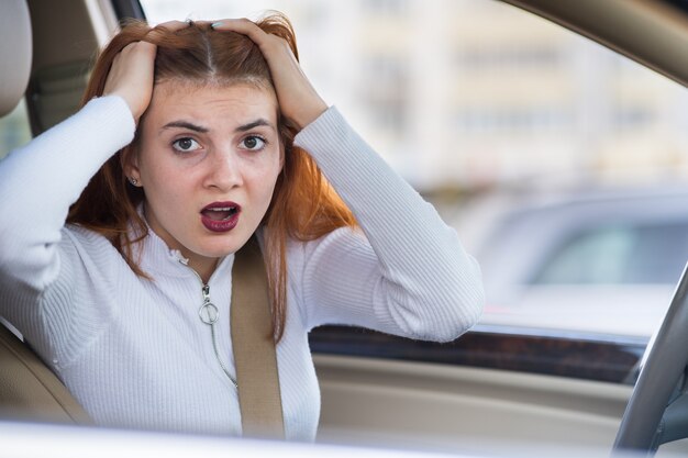 誰かに叫んで車を運転して怒って怒っている積極的な女性の腹を立ててのクローズアップの肖像画。負の人間の表現の概念。