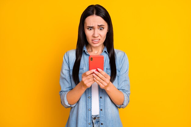 Closeup portrait of puzzled worried confused girl holding in hand cell