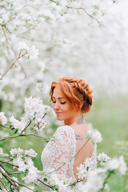 Closeup portrait of a redhaired woman in white blossom