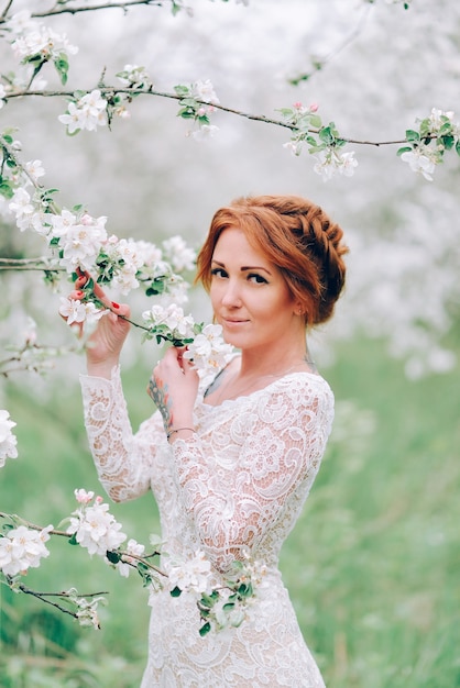 Closeup portrait of a redhaired woman in white blossom