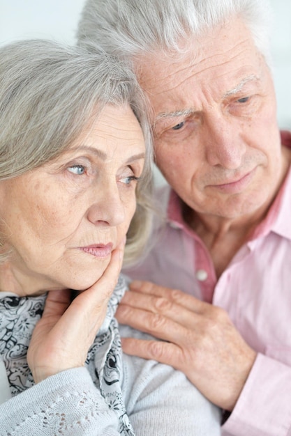 Closeup portrait of sad senior couple posing