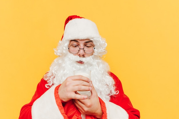 Closeup portrait of Santa Claus holding a glass of milk