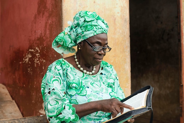 Closeup portrait of senior african black woman reading a book